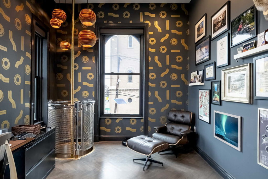 Dark office with black and gold features and leather furniture. 