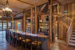 Side view of the bar adorned with a natural wood countertop. It is long and curved.