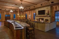 A view of the spacious interior and side view of the bar adorned with a natural wood countertop.
