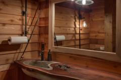 The bathroom is simple and yet full of details like custom natural wood vanity and industrial accents.